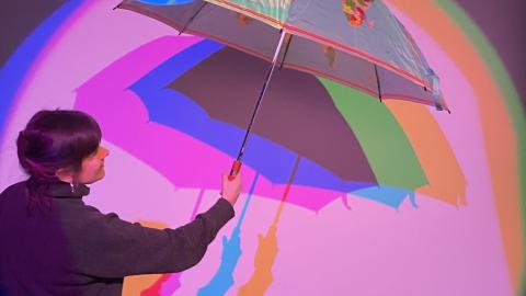 Students explore artistic expression using colors and an umbrella.