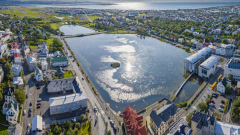 Séð yfir Tjörnina og Ráðhús Reykjavíkur í sól og góðu veðri
