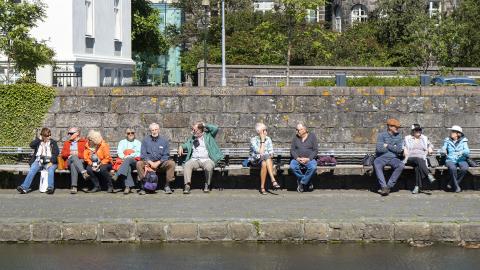 A group of older adults sits by Tjörnin pond in Reykjavík