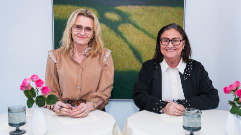 Inga Sæland, mennta- og barnamálaráðherra og Heiða Björg Hilmisdóttir borgarstjóri í Reykjavík undirrita samning um að styðja við og auka aðgengi barna og ungmenna á aldrinum 16–25 ára að skipulögðu frístunda- og félagsstarfi í Breiðholti. Heiða til vinstri, Inga til hægri, málverk í bakgrunni. Standa við borð.