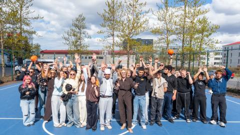Hópur af ungmennum með borgarstjóra á körfuboltavellinum endubætta í Völvufelli.