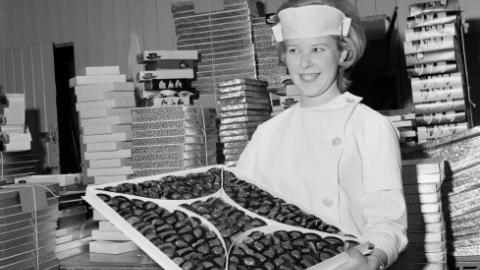 Image from the Nói candy factory tour, a female employee holding a box of chocolates.